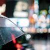 雨の中、傘を差してうまくいかないなと落ち込む女性